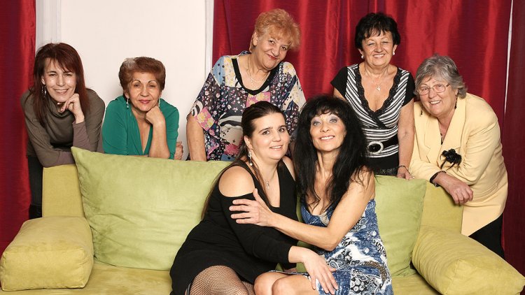Old and young lesbians perform in a room full of mature ladies