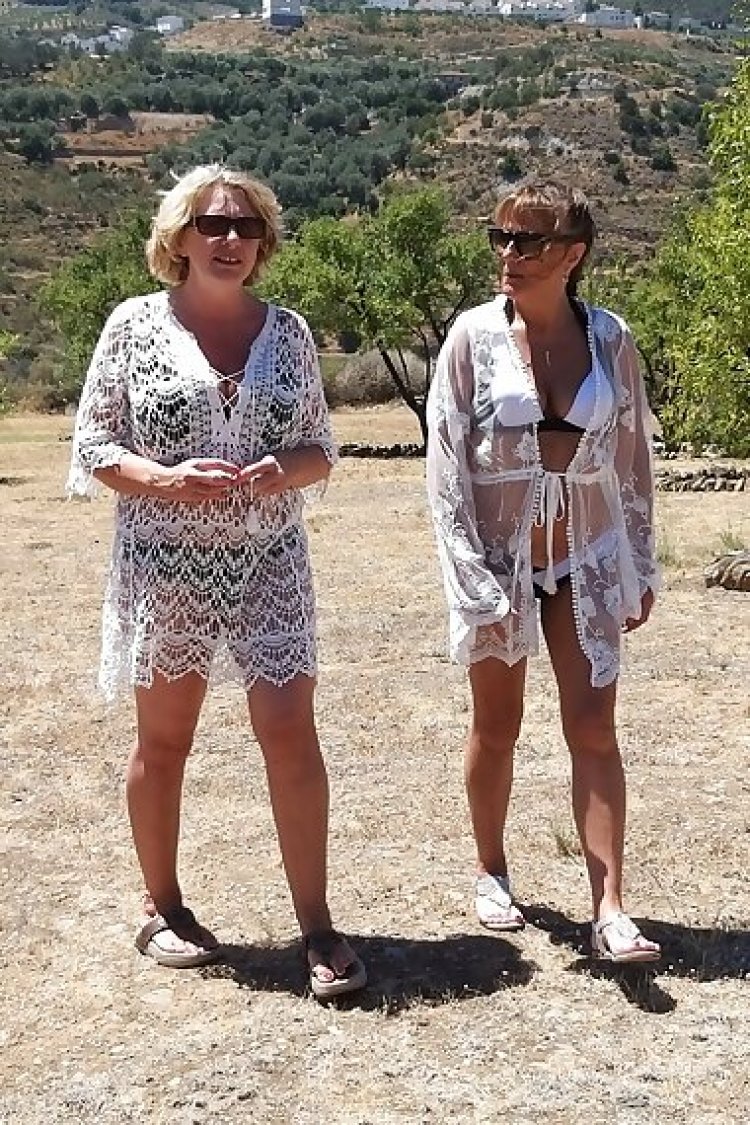 Two mature lesbians are licking in an open field in the sun